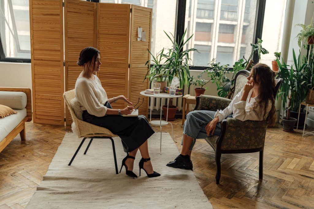 Two women sit in a therapy session, creating a tranquil and professional environment.